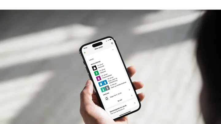 Person som holder mobil med appen MinRenovasjon