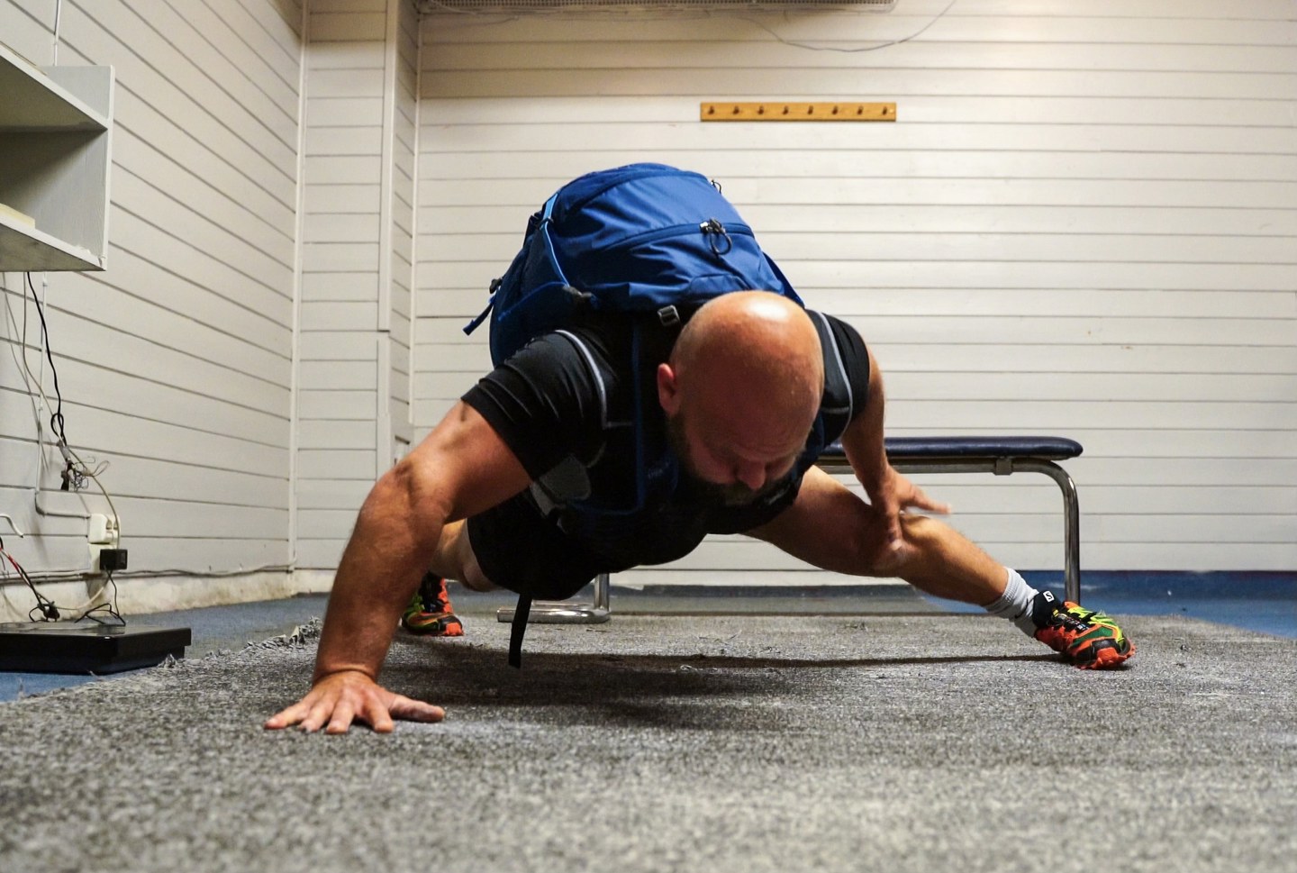 Sverre Diesen tar push-ups på en hånd med vekt på ryggen.