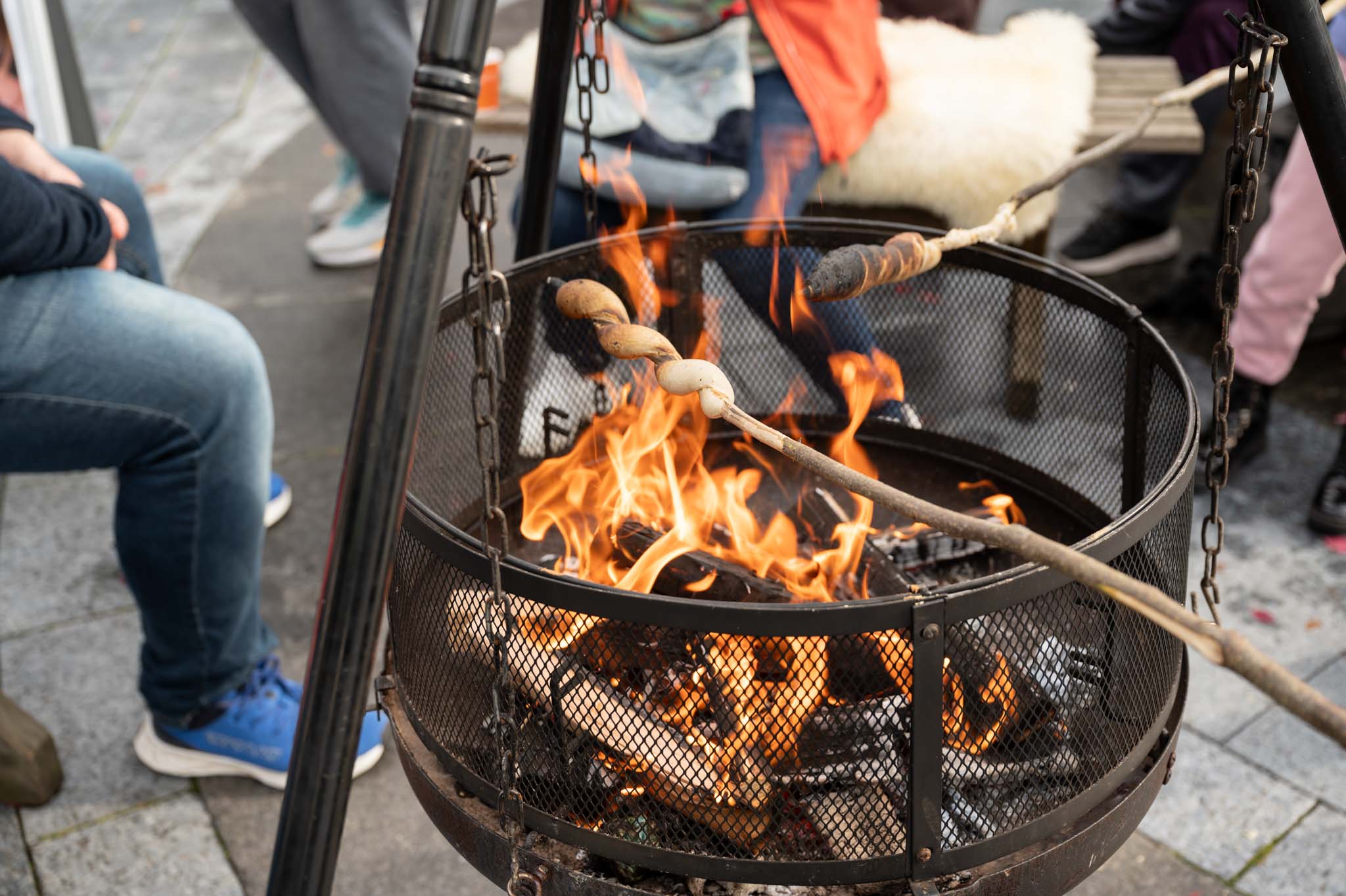 Bilde av bålpanne med mennesker som griller pinnebrød