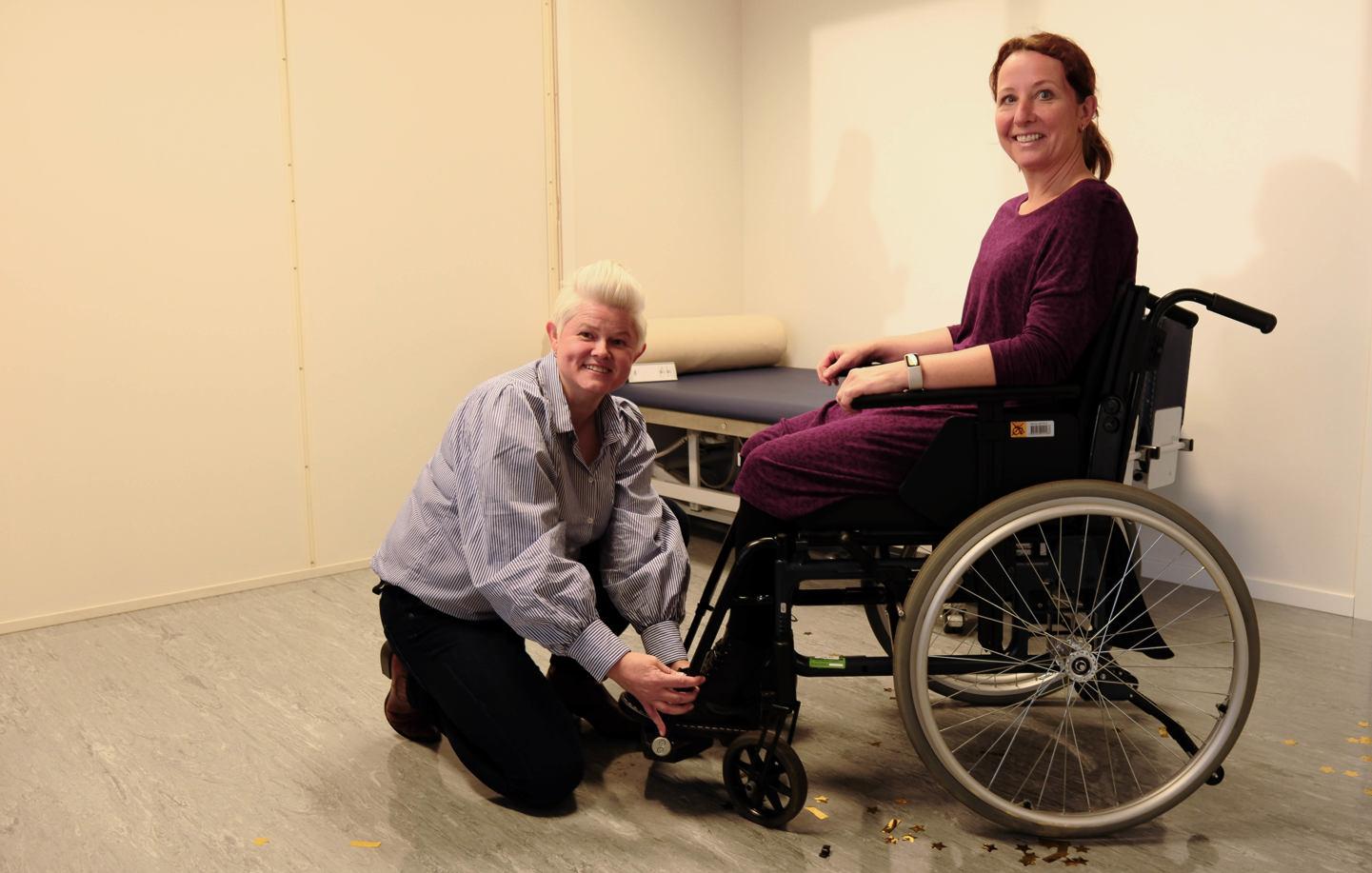 Avdelingsleder Birgit Pedersen viser oss hvordan en rullestol tilpasses sammen med ergoterapeut Cecilie Charlesen. .