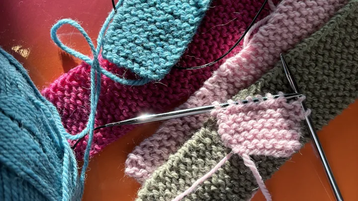 Strikkede lapper som ligger på et bord